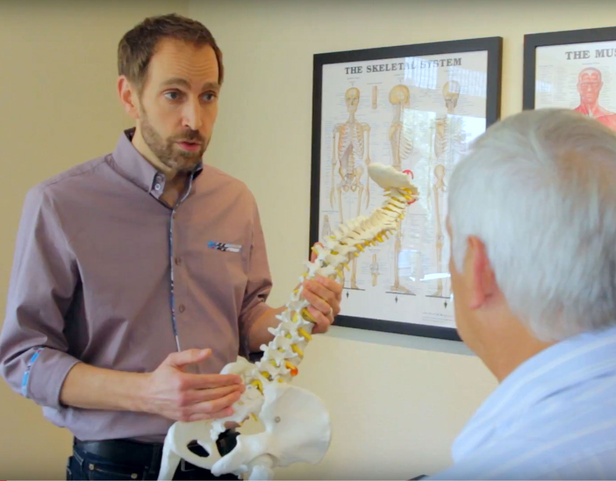 Dr. Rehl explaining to patient about conditions treated in office, including back and neck pain, sciatica, migraines, and more